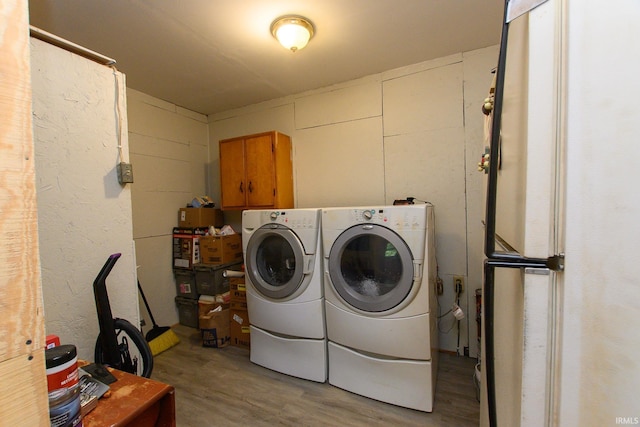 clothes washing area with washing machine and clothes dryer, concrete block wall, and laundry area