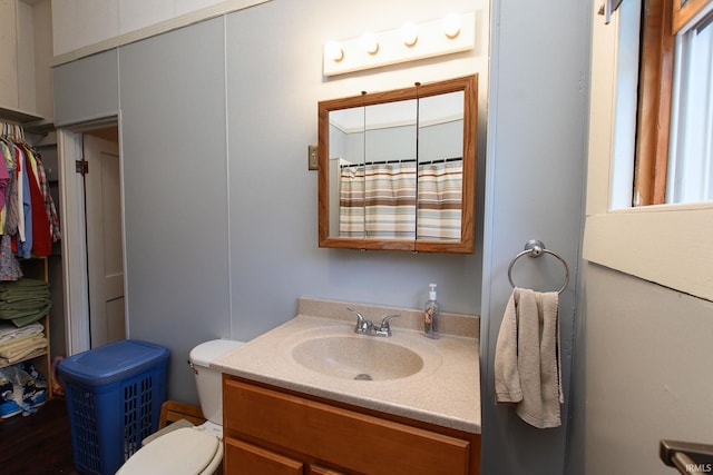 bathroom with curtained shower, toilet, and vanity