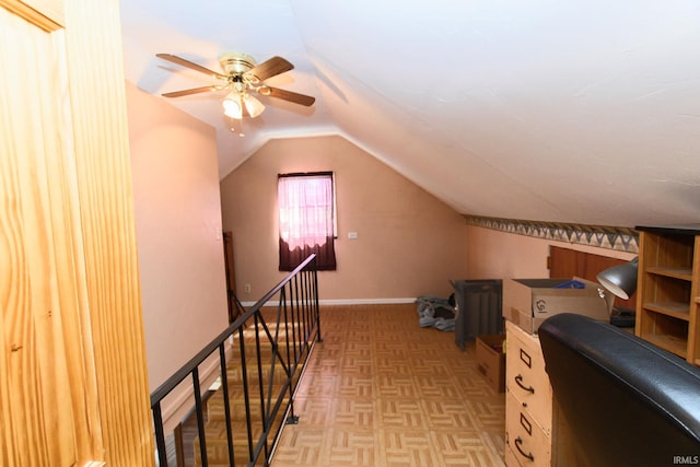 office space featuring light colored carpet, ceiling fan, lofted ceiling, and baseboards