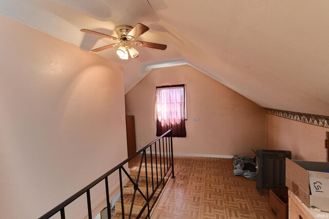 bonus room featuring lofted ceiling, a ceiling fan, and baseboards