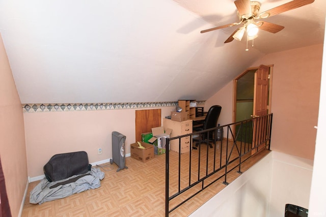 office area with ceiling fan, vaulted ceiling, and baseboards