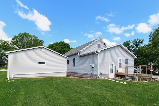 rear view of property featuring a yard and a deck
