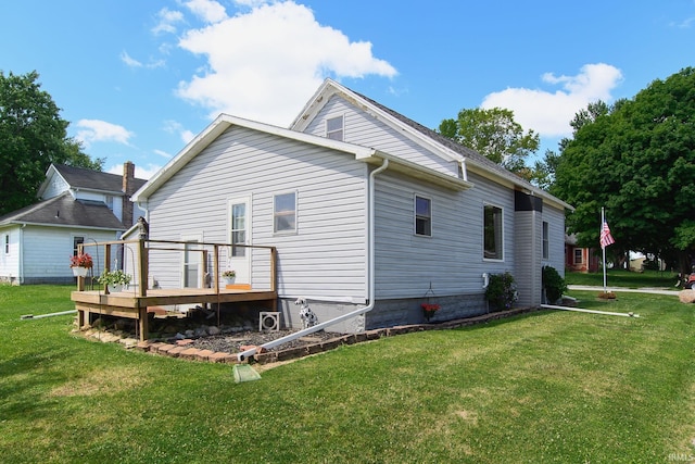 rear view of house with a lawn and a wooden deck
