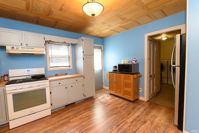 kitchen featuring freestanding refrigerator, under cabinet range hood, white gas range oven, and light wood-type flooring