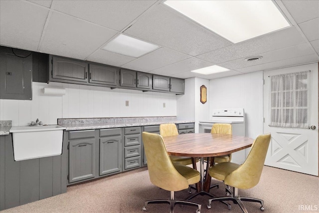 carpeted dining space featuring visible vents, electric panel, a paneled ceiling, and a sink