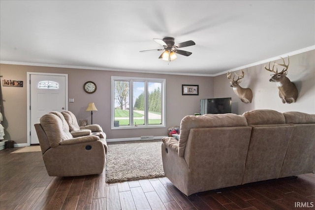 living room with crown molding, a ceiling fan, dark wood-style flooring, and a healthy amount of sunlight
