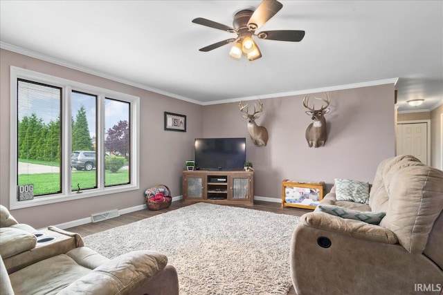 living area featuring visible vents, a ceiling fan, wood finished floors, and ornamental molding