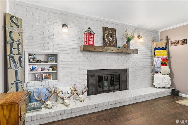 living area featuring baseboards, ornamental molding, a brick fireplace, and wood finished floors