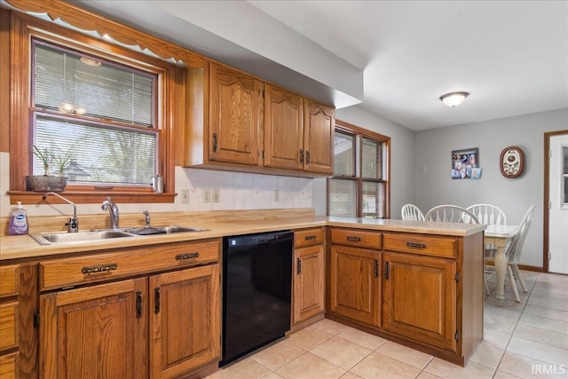 kitchen with light countertops, dishwasher, a peninsula, and a sink