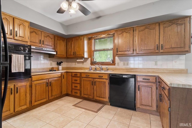kitchen featuring a sink, black appliances, brown cabinets, light countertops, and under cabinet range hood