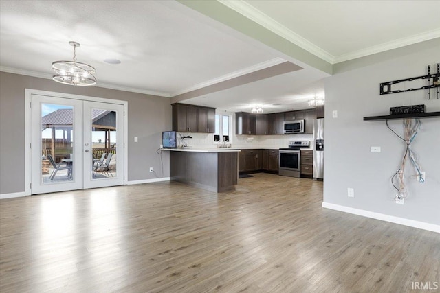 1689 E 550 Rd S, Peru, IN 46970 - kitchen featuring dark brown cabinets, open floor plan, a chandelier, light countertops, and appliances with stainless steel finishes