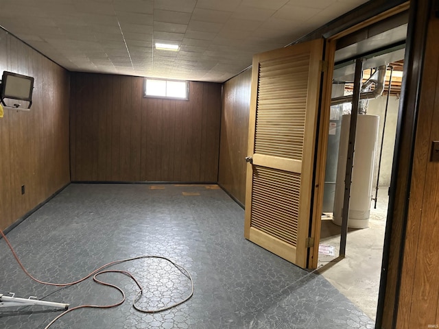 below grade area featuring wooden walls and gas water heater