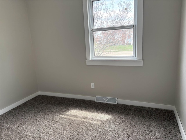 unfurnished room with carpet floors, visible vents, and baseboards