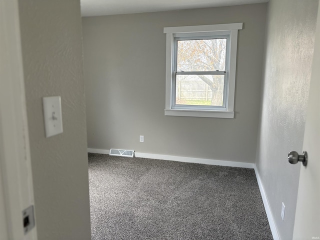 carpeted empty room with visible vents and baseboards