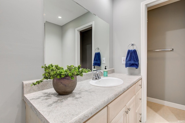 bathroom featuring baseboards, vanity, and recessed lighting