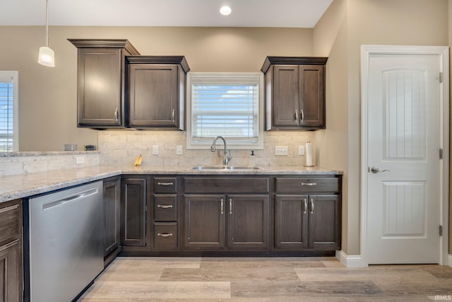kitchen with dark brown cabinets, stainless steel dishwasher, a sink, and tasteful backsplash