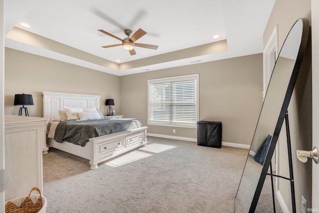 carpeted bedroom featuring recessed lighting, a raised ceiling, baseboards, and ceiling fan