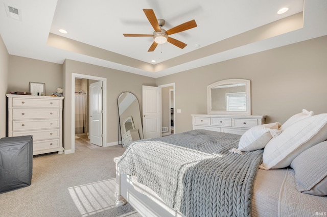 bedroom featuring recessed lighting, a tray ceiling, visible vents, baseboards, and light colored carpet