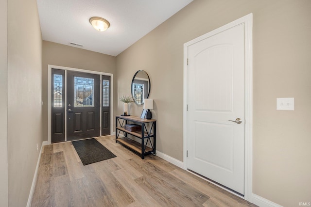 foyer with baseboards, visible vents, and light wood-style floors