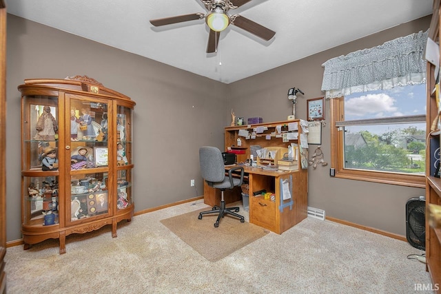 carpeted home office with baseboards, a ceiling fan, and visible vents