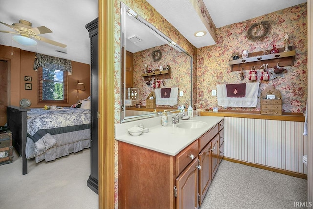 ensuite bathroom with a ceiling fan, wallpapered walls, connected bathroom, vanity, and visible vents