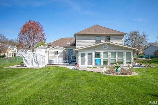 back of property featuring fence, a lawn, an outbuilding, and a storage unit