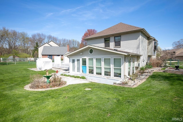 back of house featuring a lawn and fence