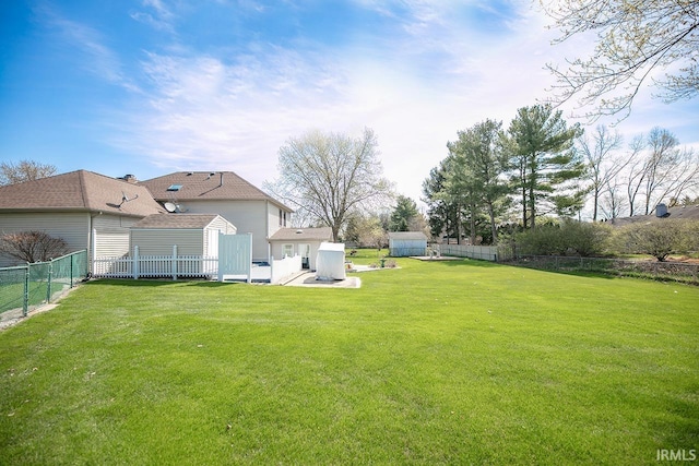 view of yard featuring fence, an outbuilding, and a storage shed