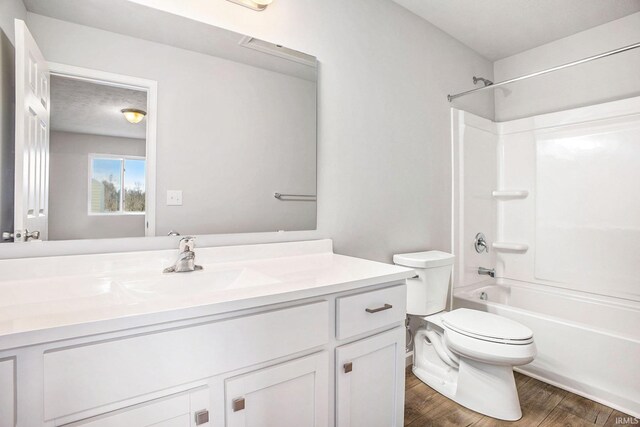 bathroom featuring toilet, shower / bathtub combination, vanity, and wood finished floors