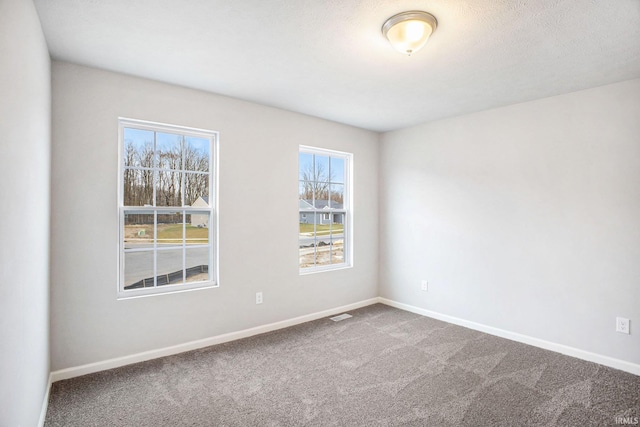 unfurnished room featuring visible vents, baseboards, and carpet flooring