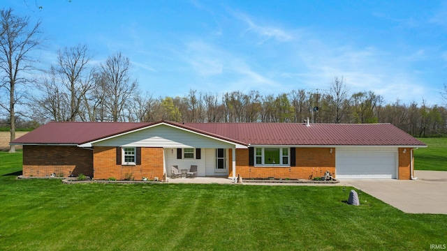single story home with a garage, driveway, a front yard, metal roof, and brick siding