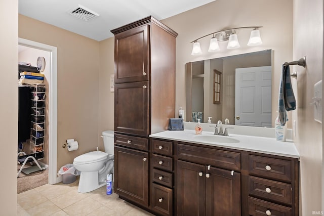bathroom featuring a spacious closet, tile patterned floors, visible vents, toilet, and vanity