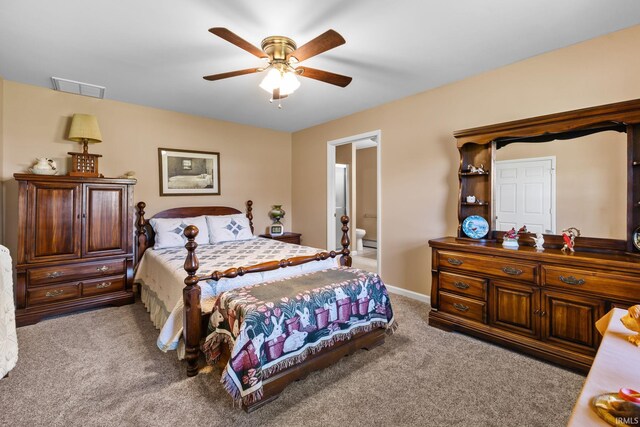 carpeted bedroom with baseboards, ensuite bath, visible vents, and a ceiling fan