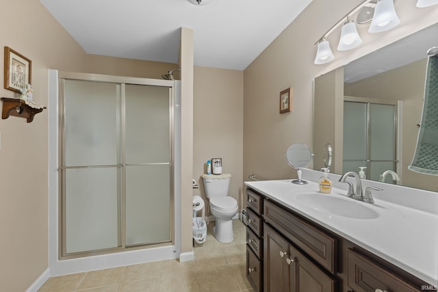 bathroom with a shower stall, tile patterned floors, vanity, baseboards, and toilet