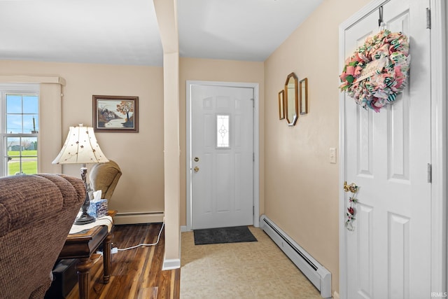 entrance foyer featuring a baseboard heating unit, light wood finished floors, and baseboards