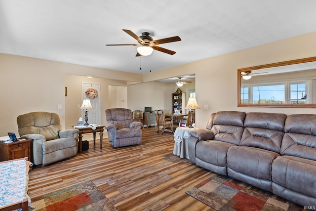 living area with wood finished floors and a ceiling fan