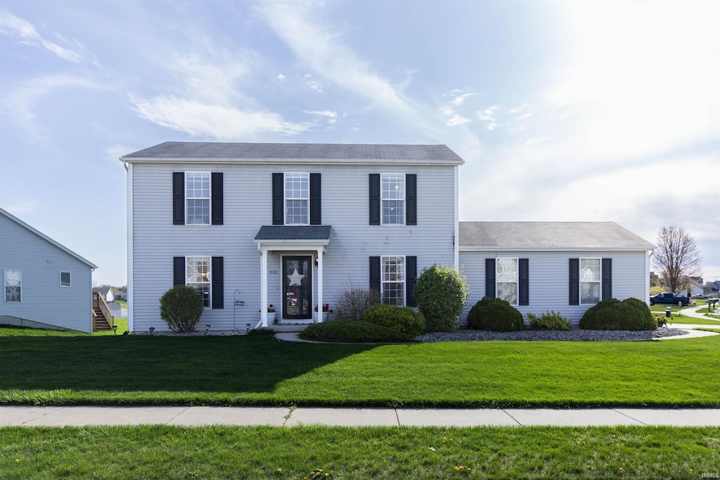 colonial inspired home with a front lawn
