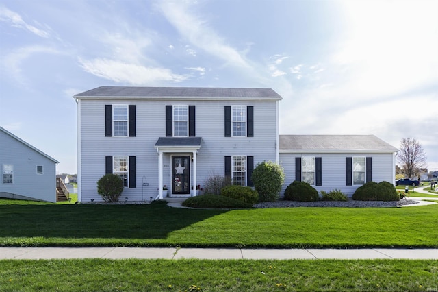 colonial inspired home with a front lawn