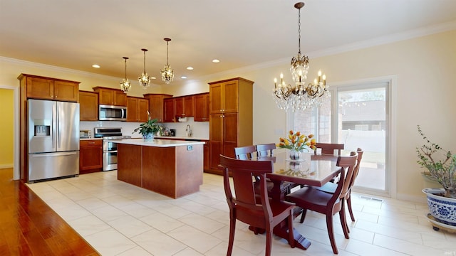 3512 Forestdale Dr, Newburgh, IN 47630 - kitchen featuring a chandelier, pendant lighting, stainless steel appliances, light countertops, and ornamental molding