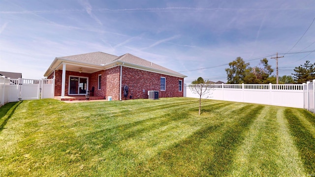 3512 Forestdale Dr, Newburgh, IN 47630 - back of house featuring a fenced backyard, cooling unit, brick siding, a ceiling fan, and a yard