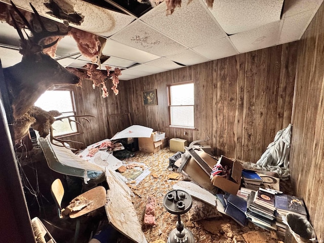 misc room featuring wooden walls and a paneled ceiling