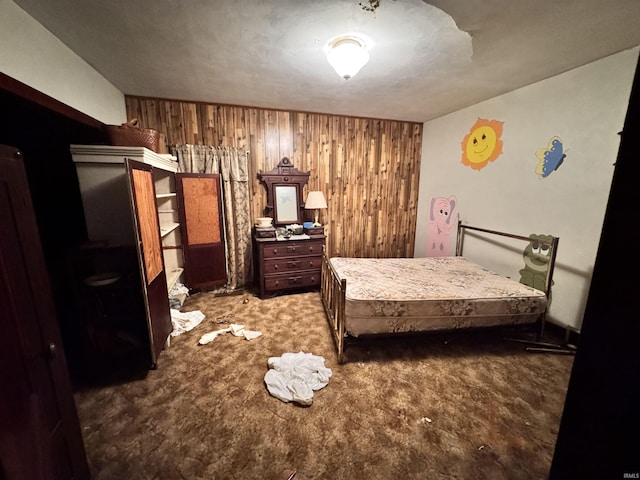 bedroom featuring wooden walls and carpet flooring