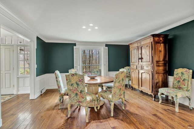 2818 Little Turtle Trl, Fort Wayne, IN 46804 - dining area featuring a wainscoted wall, light wood-type flooring, baseboard heating, a decorative wall, and ornamental molding