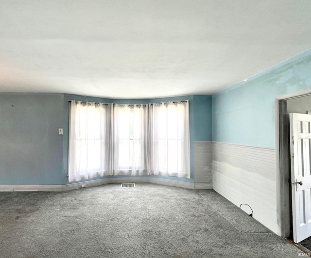 857 Byron St, Huntington, IN 46750 - carpeted empty room featuring healthy amount of natural light, a wainscoted wall, and baseboards