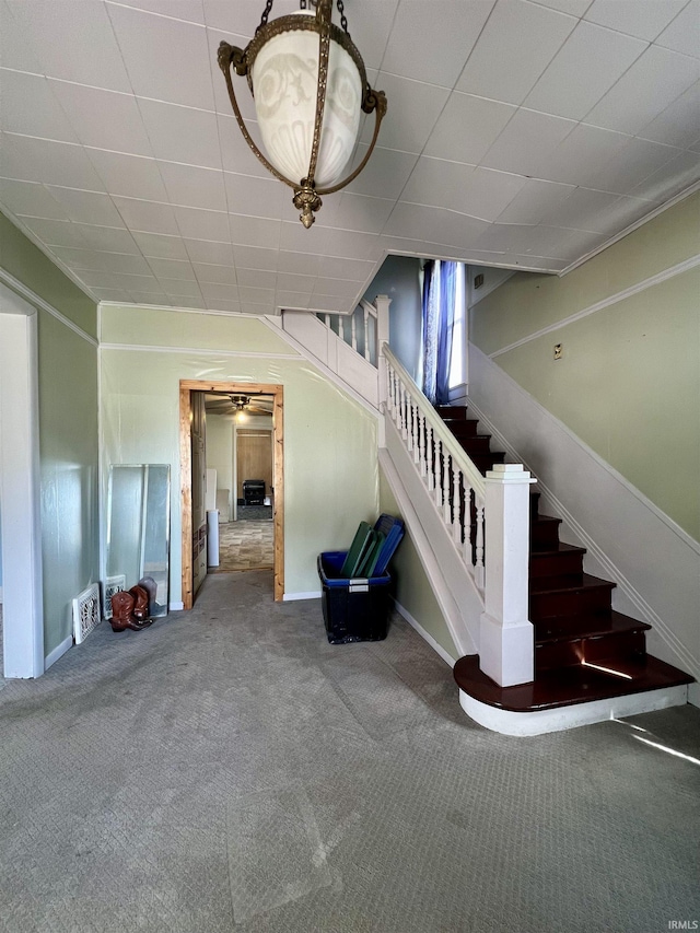 staircase featuring carpet floors and baseboards