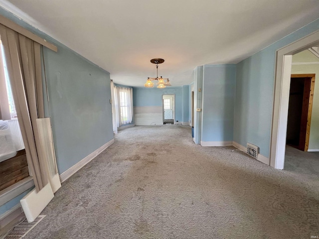 spare room with visible vents, baseboards, carpet flooring, and a chandelier