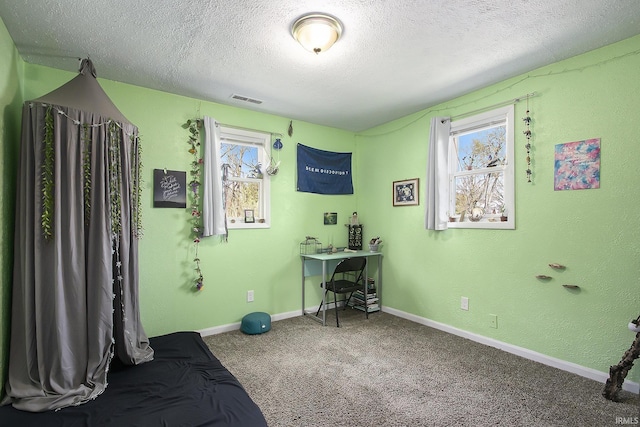 bedroom featuring baseboards, carpet floors, visible vents, and a textured ceiling