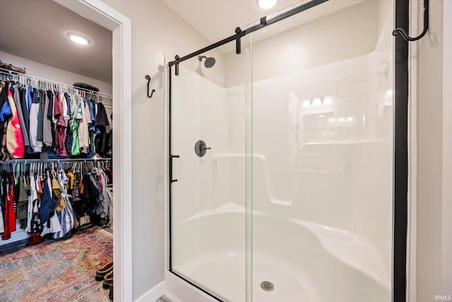 full bath featuring a shower stall, a spacious closet, and recessed lighting