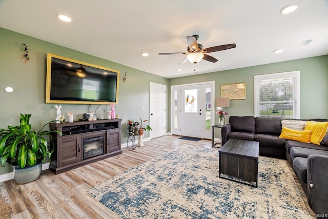 living room featuring a ceiling fan, wood finished floors, baseboards, visible vents, and recessed lighting