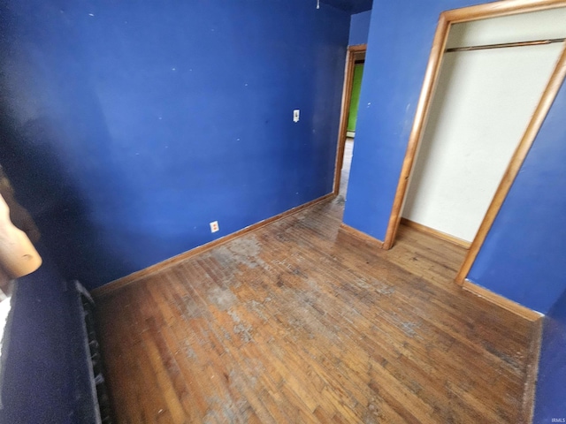 unfurnished bedroom featuring baseboards and wood finished floors